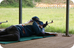 man shooting prone rifle